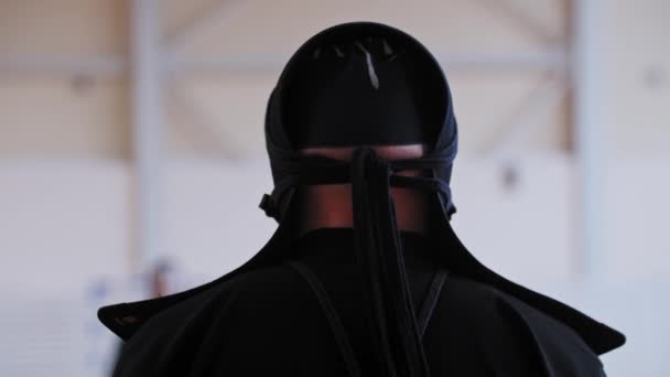 Kendo toernooi - een man in nationale zwarte kleren en een cape op het hoofd wacht op zijn beurt — Stockvideo