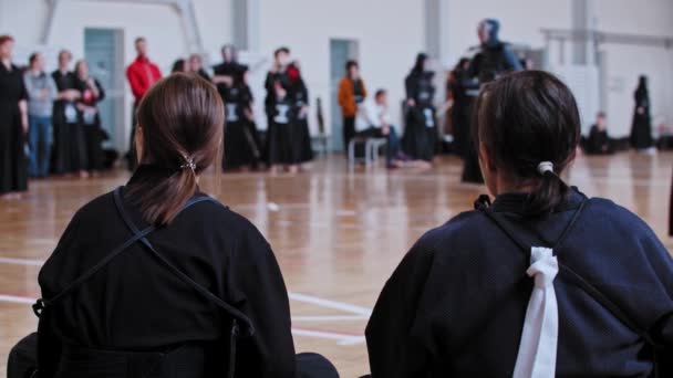 Dwie kobiety siedzą na turnieju umiejętności Kendo. — Wideo stockowe