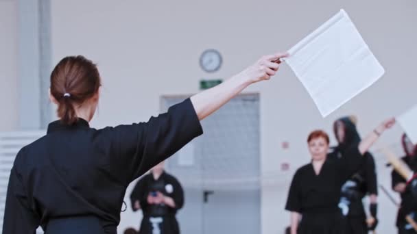 Torneio de Kendo - mulher segurando uma bandeira branca — Vídeo de Stock