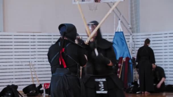 RUSIA, KAZAN 24-04-2021: Torneo de Kendo - arte marcial japonés - hombres vestidos con ropa negra tradicional peleando entre sí con espadas de bambú — Vídeo de stock