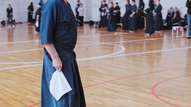 RUSIA, KAZAN 24-04-2021: Torneo de Kendo - arte marcial japonés - luchadores en ropa negra tradicional peleando entre sí con espadas de bambú y jueces viéndolos — Vídeo de stock