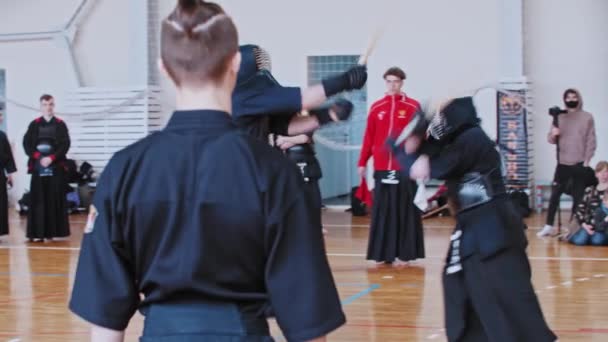 ロシア、カザン24-04-2021年:剣道大会-ジムで戦う2人の男-剃髪した寺院と戦いを見て高いポニーテールを持つ男 — ストック動画