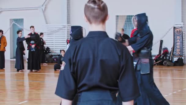 RUSSIA, KAZAN 24-04-2021: Kendo toernooi - twee mannen hebben een duel - een man met geschoren tempels en hoge paardenstaart kijken naar het gevecht — Stockvideo