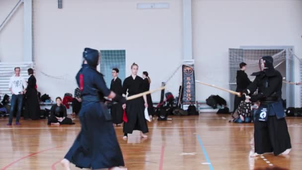 RUSIA, KAZAN 24-04-2021: Torneo de Kendo: hombres vestidos con ropa negra tradicional peleando entre sí con palos de bambú y gente viéndolo — Vídeo de stock