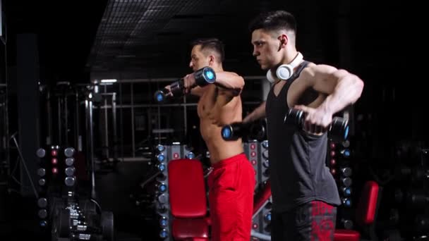 Deux beaux hommes pompant leurs mains regardant dans le miroir dans la salle de gym — Video
