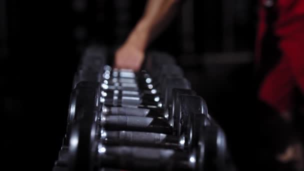 Dos hombres en forma tomando pesas desde el estrado en el gimnasio — Vídeo de stock