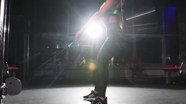 Тренування в спортзалі - молода жінка накачує їй сідниці за допомогою тренувального обладнання — стокове відео