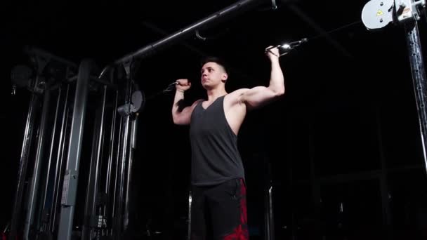 Entrenamiento en el gimnasio - joven hombre guapo entrenando sus manos usando equipo de ejercicio — Vídeo de stock