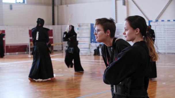 Oroszország, KAZAN 24-04-2021: Kendo torna - japán harcművészet - a fekete ruhás férfiak bambusz botokkal kezdenek harcolni egymással — Stock videók