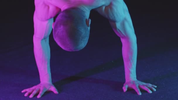 Junger aufgepumpter Typ in Jeanshosen, der auf seinen Händen steht und seinen Körper zu Boden wirft — Stockvideo