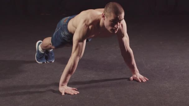 Молодий підкачаний хлопець в джинсових шортах робить вправи на витривалість для його рук і плечей — стокове відео