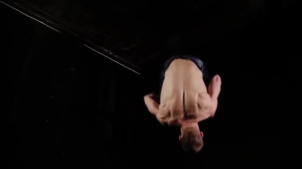 Un jeune sportif faisant un backflip et faisant un push up en studio noir — Video