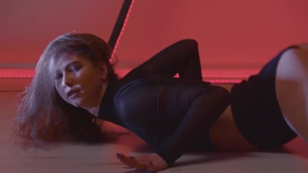 Сексуальна жінка в крихітному вбранні спокуслива танцює на підлозі на колінах — стокове відео