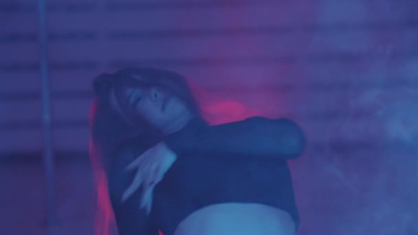 Жінка сексуально танцює в диму і неоновому освітленні — стокове відео