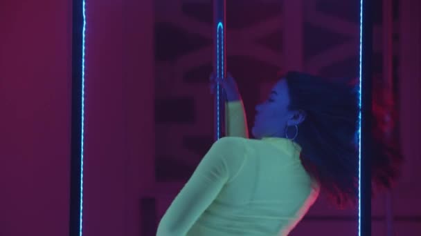 Взрослая женщина соблазнительные танцы на шесте в неоновом освещении — стоковое видео