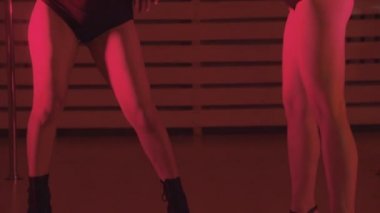 Kırmızı ışıkta dans eden iki seksi kadın.