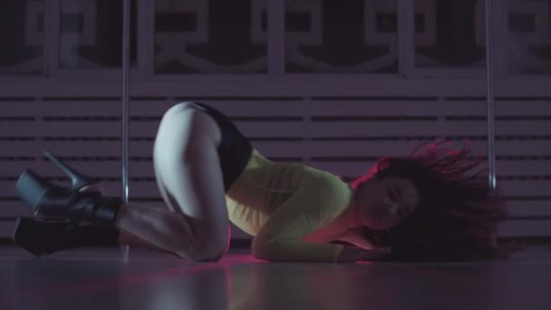 Ελκυστική γυναίκα εκτελεί σέξι χορό στο πάτωμα σε κόκκινο φωτισμό — Αρχείο Βίντεο