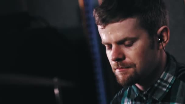 Бородатий чоловік в маленьких навушниках, що б'ють по барабанах — стокове відео