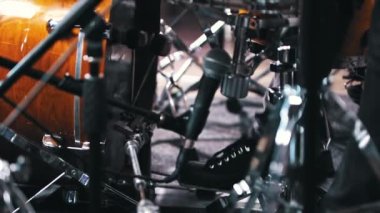 Stüdyoda davul çalan genç adam ayaklarıyla topa vuruyor.