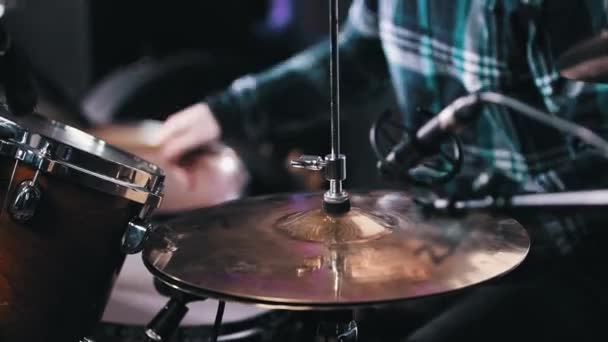 Молодий чоловік у плетеній сорочці грає на барабанах — стокове відео