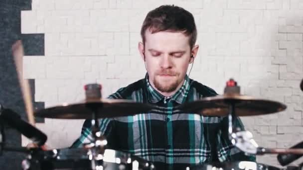 Jongeman in kleine koptelefoon speelt drums op plaat in de studio — Stockvideo