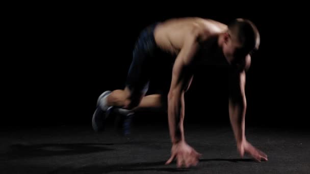 Young pumped man trains in the arena - doing a back flip and doing push ups — Stock Video