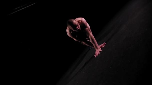 Junger gepumpter Mann trainiert seine Hände mit Liegestützen in der dunklen Arena — Stockvideo