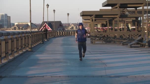 Ung sportig man joggar på kajen — Stockvideo