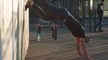 Spor sahasında baş aşağı duran sporcu.