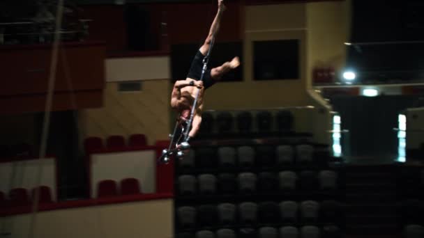 Hombre acrobático volando boca abajo en la rotación de rendimiento en la arena del circo — Vídeos de Stock