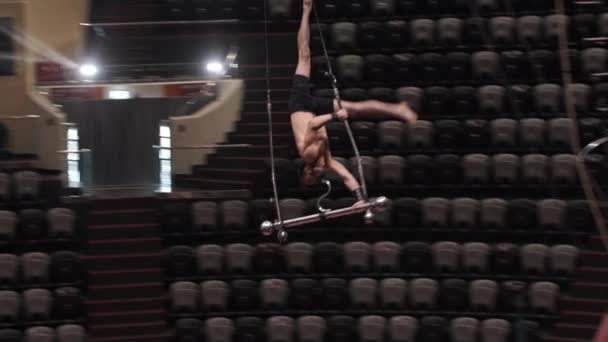 En akrobatisk man flyger runt upp och ner på cirkusarenan. — Stockvideo