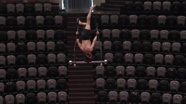 Hombre acrobático levantándose boca abajo en el rendimiento en lo alto en la arena del circo — Vídeos de Stock
