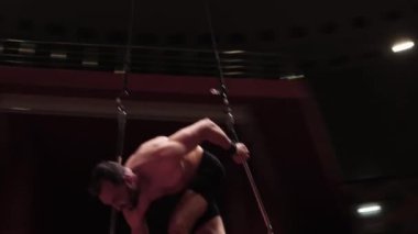 Sirkte antrenman. Sahne inşaatı için arenada uçan akrobatik bir adam.