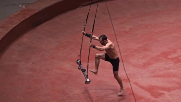 Um homem acrobático prestes a fazer um show na construção voadora balançando a construção para o lado — Vídeo de Stock