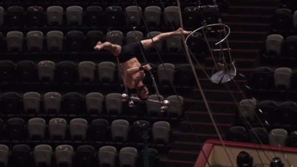 Um homem acrobático fazendo um show na construção voadora em uma arena de circo vazia — Vídeo de Stock