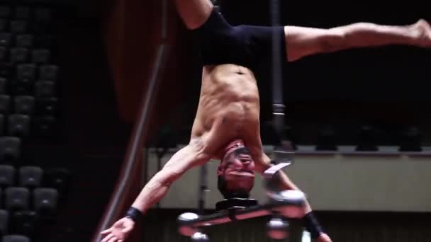 Un acrobate tournant à l'envers sur la barre volante au cirque — Video