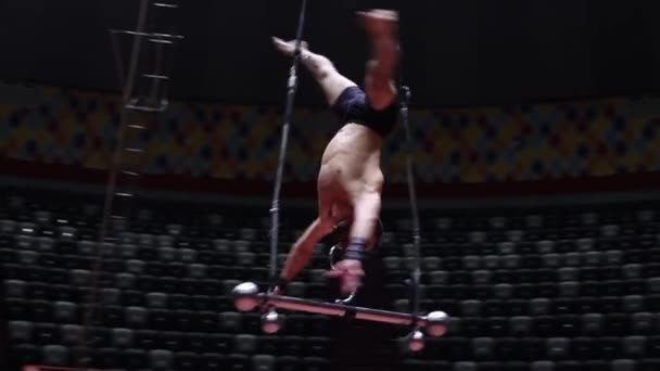 Un acrobate montrant une performance sur la barre volante au cirque - tournant sans le support — Video