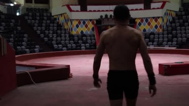 Ein akrobatischer Mann geht in eine leere Zirkusarena — Stockvideo