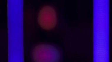 Parlak kırmızı ve mavi ışıkta dans eden seksi kadın.