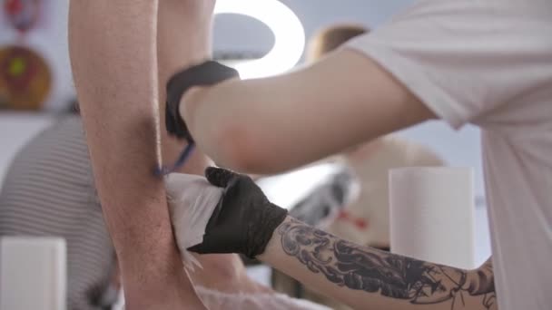 Joven se afeita la pierna de su cliente — Vídeos de Stock