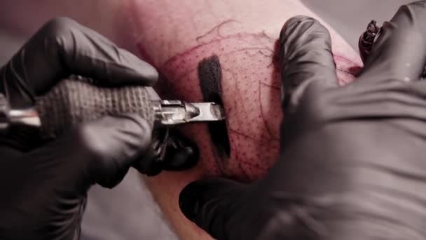 Eine Sitzung im Tätowiersalon - Füllen des Tattoos mit schwarzer Farbe — Stockvideo