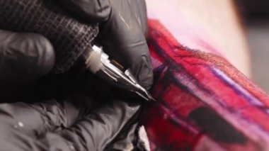 Doing a tattoo - tattooing the letters over red sketch