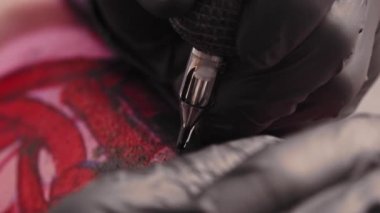 Tattoo session - tattooing the letters over red sketch