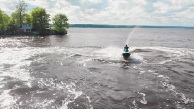 KAZAN, RUSSIA 21-05-21: a man riding yellow jet ski with a little boy - aerial view