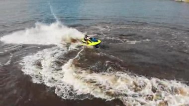 KAZAN, RUSSIA 21-05-21: a man riding yellow jet ski - aerial view