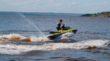 KAZAN, RUSSIA 21-05-21: a man riding yellow jet ski in circles in the river