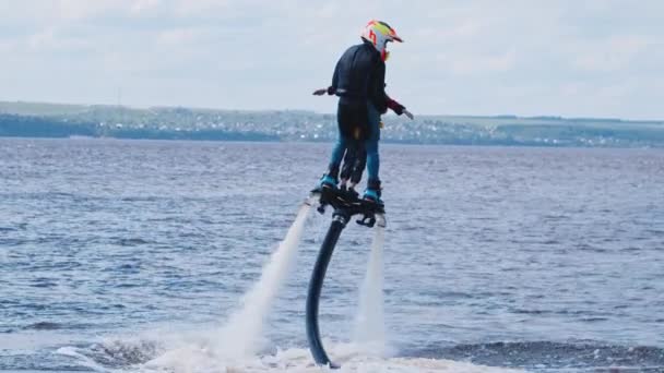 KAZAN, RUSSIA 21-05-21: sportieve man met een klein kind op een flyboard over de rivier — Stockvideo