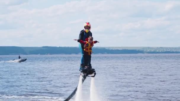 KAZAN, RUSSIA 21-05-21: sportivo con un bambino su un flyboard sul fiume — Video Stock