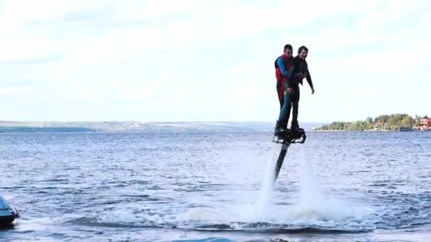 Twee mannen die flyboards leren gebruiken op de rivier. — Stockvideo