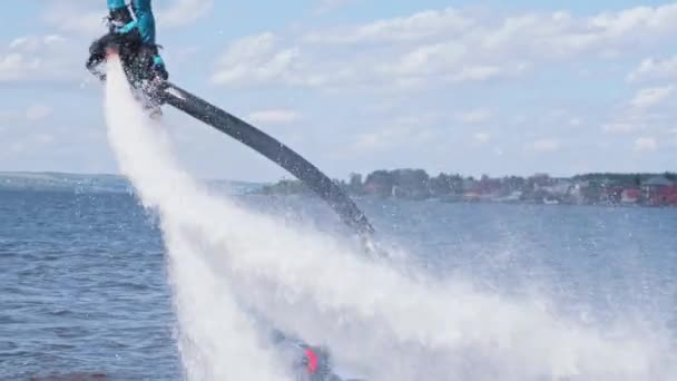 En sportig man som flyger ovanför floden på ett flyboard och faller ner i vattnet. — Stockvideo
